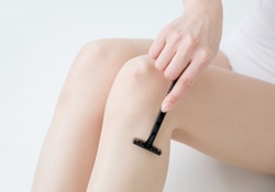 脚をカミソリで脱毛する女性