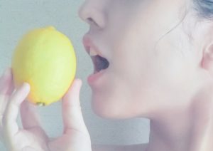シミ・くすみに良いレモンを食べる女性