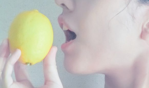 シミ・くすみに良いレモンを食べる女性